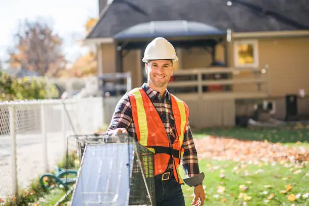Technician placing locked bait station near exterior wall